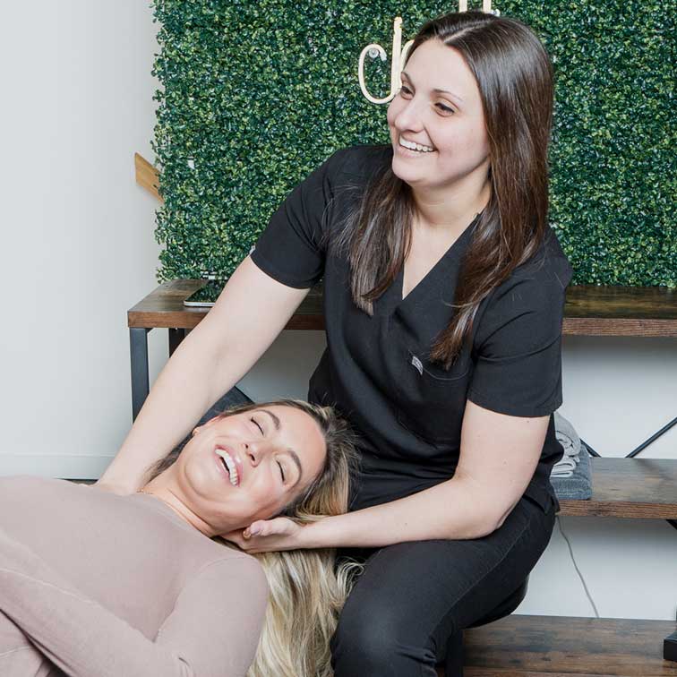 Dr. Abby Dante cradling a patient's head and working the muscles where her neck meets the top of her shoulder