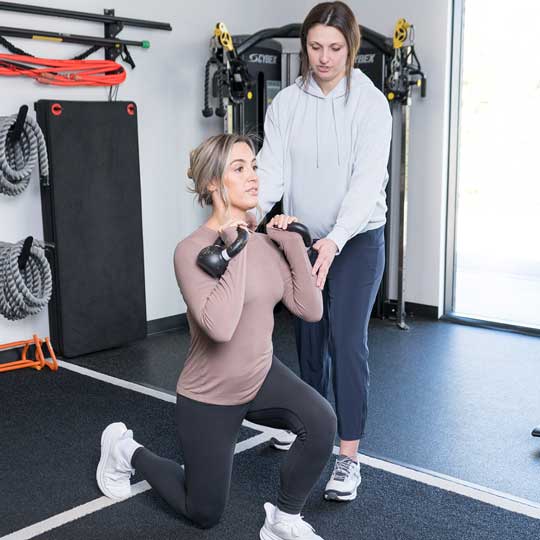 Dr. Abby Dante coaching a patient through a kettlebell lunge