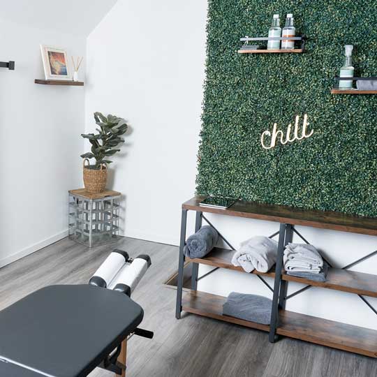 Treatment room with a boxwood wall and shelves of rolled towels